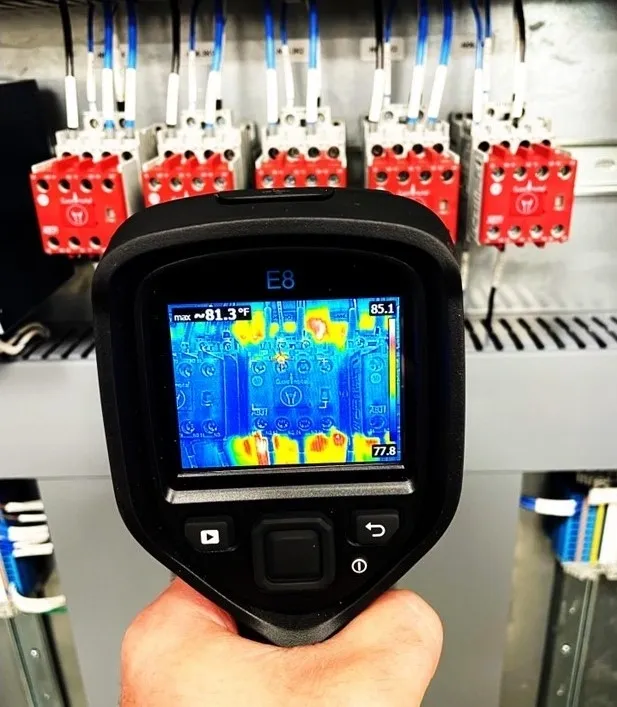 A person holding up a thermal camera to take a picture.